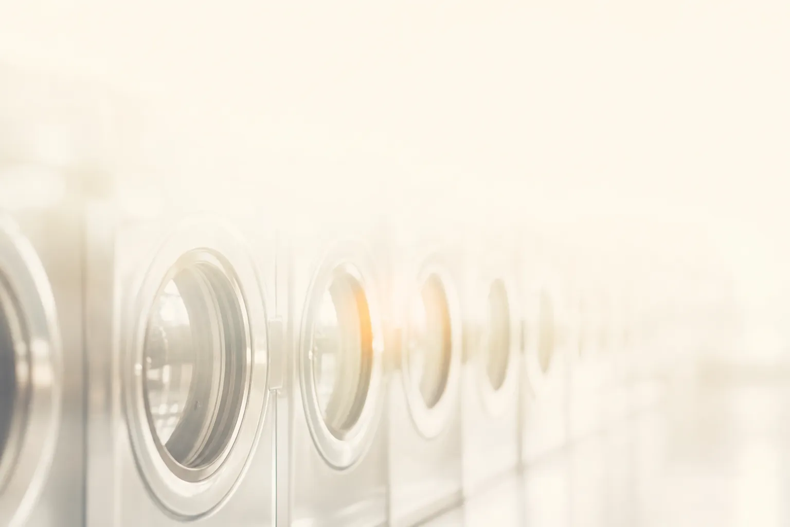 Commercial washers and dryers glowing inside a LaundryHub outlet